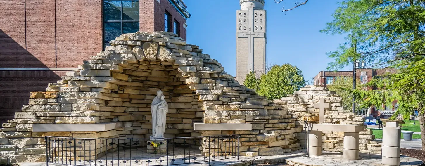 A sculpture underneath a stone grotto on campus.